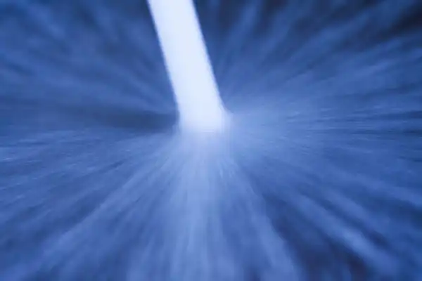Close-up of a blue abstract pattern with a bright white streak extending from the center, resembling a burst of light or motion, reminiscent of the powerful force found in a hydro jetting service.